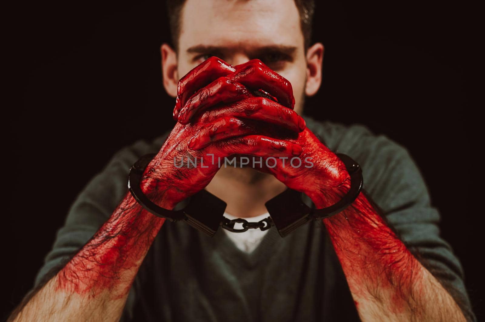 Portrait of a man with bloody hands handcuffed