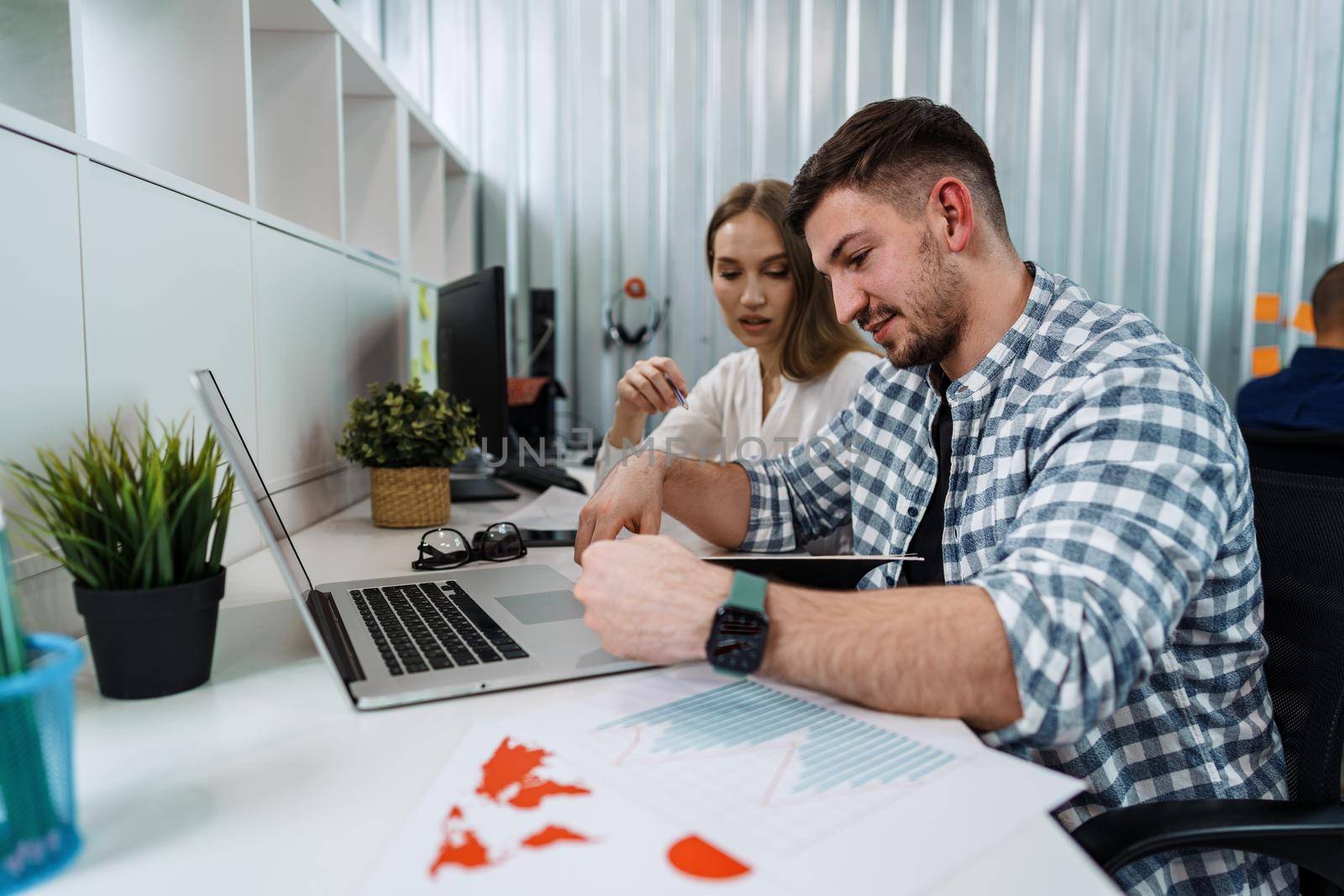 Two entrepreneurs man and woman sitting together working in an office by Fabrikasimf