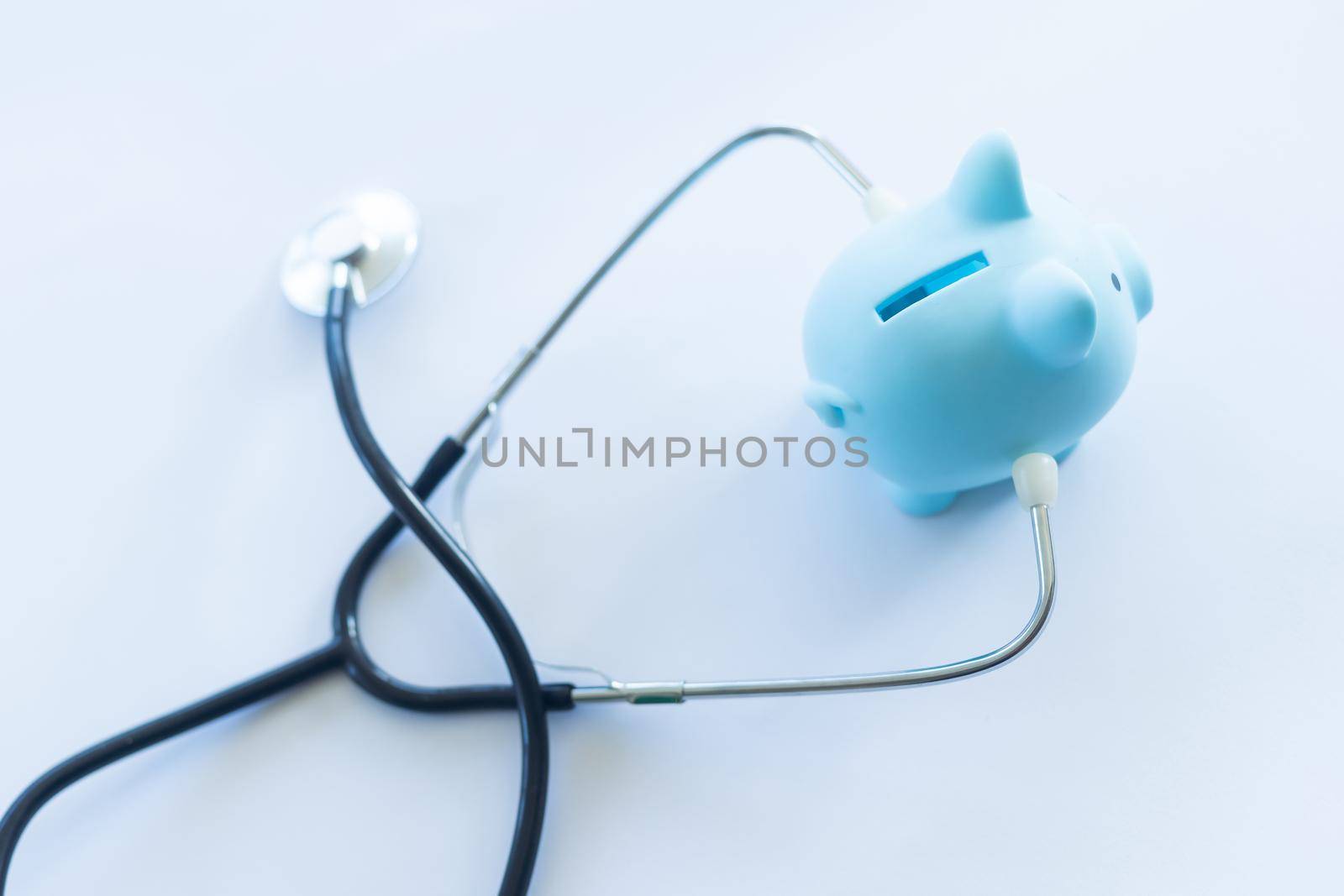 Piggy bank with stethoscope isolated on white. by Andelov13