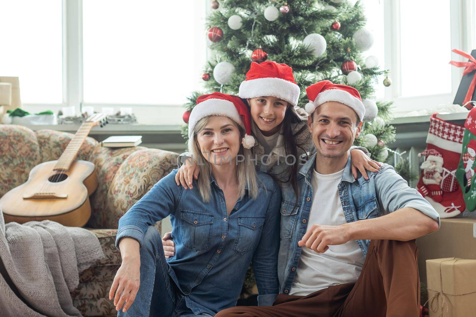 family having fun and playing together near Christmas tree indoors