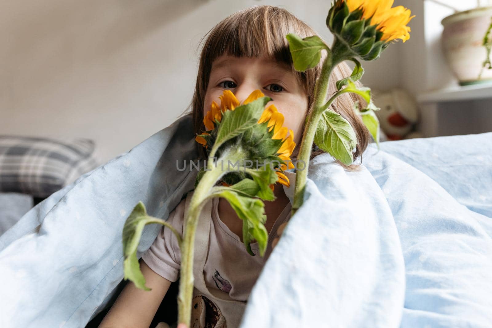 Portrait of a toddler girl holding sunflowers. High quality photo