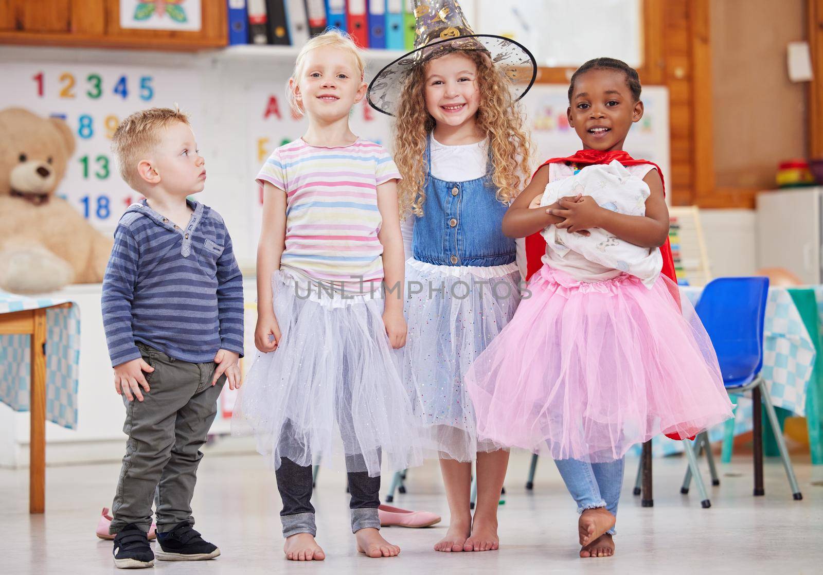 We love dressing up and playing together. Shot of a group of preschool children playing dress-up in class. by YuriArcurs