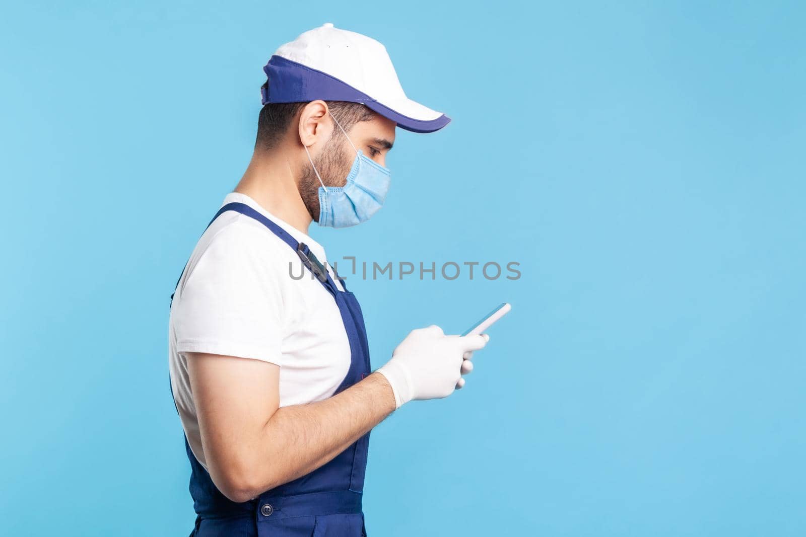 Portrait of worker man in uniform on blue background. by Khosro1