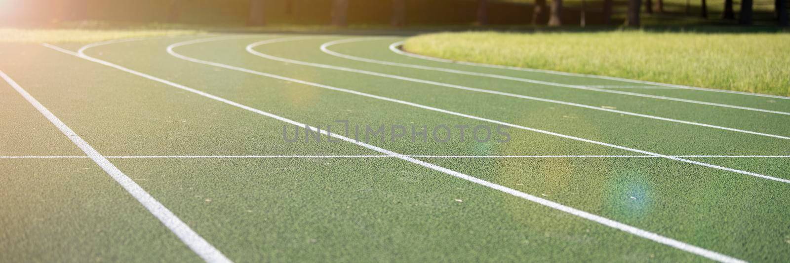Running track at the stadium. Rubber coated green. Running track in the park outdoors, summer.