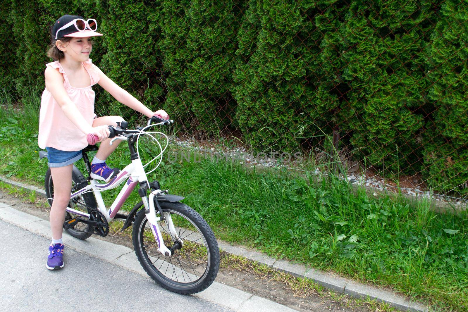 a child girl has damaged a bicycle wheel and is making repairs photo without processing. High quality photo