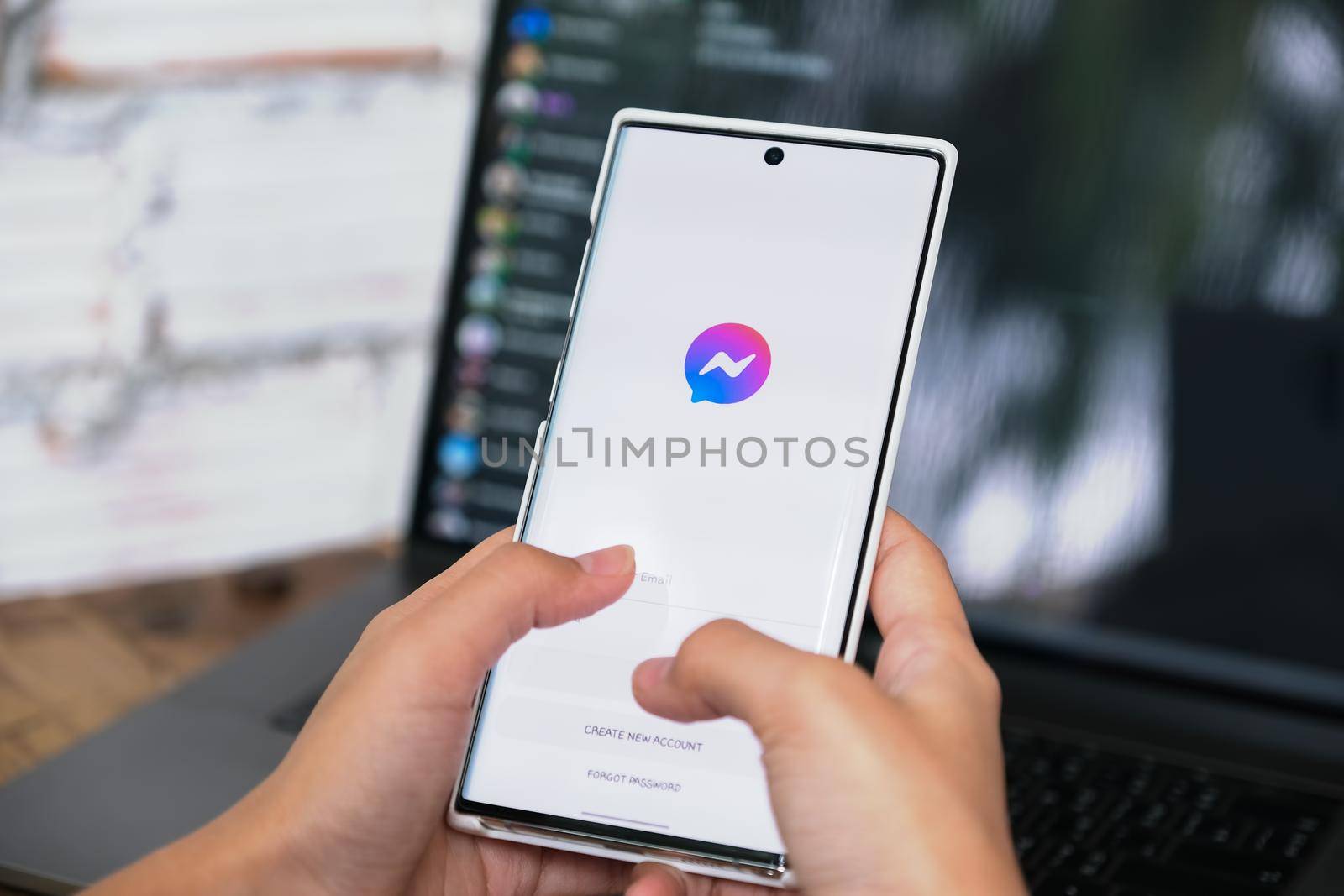 CHIANG MAI, Thailand - JUNE 06, 2021: Woman holding smartphone mobile with social networking service Facebook Messenger on the screen by Manastrong