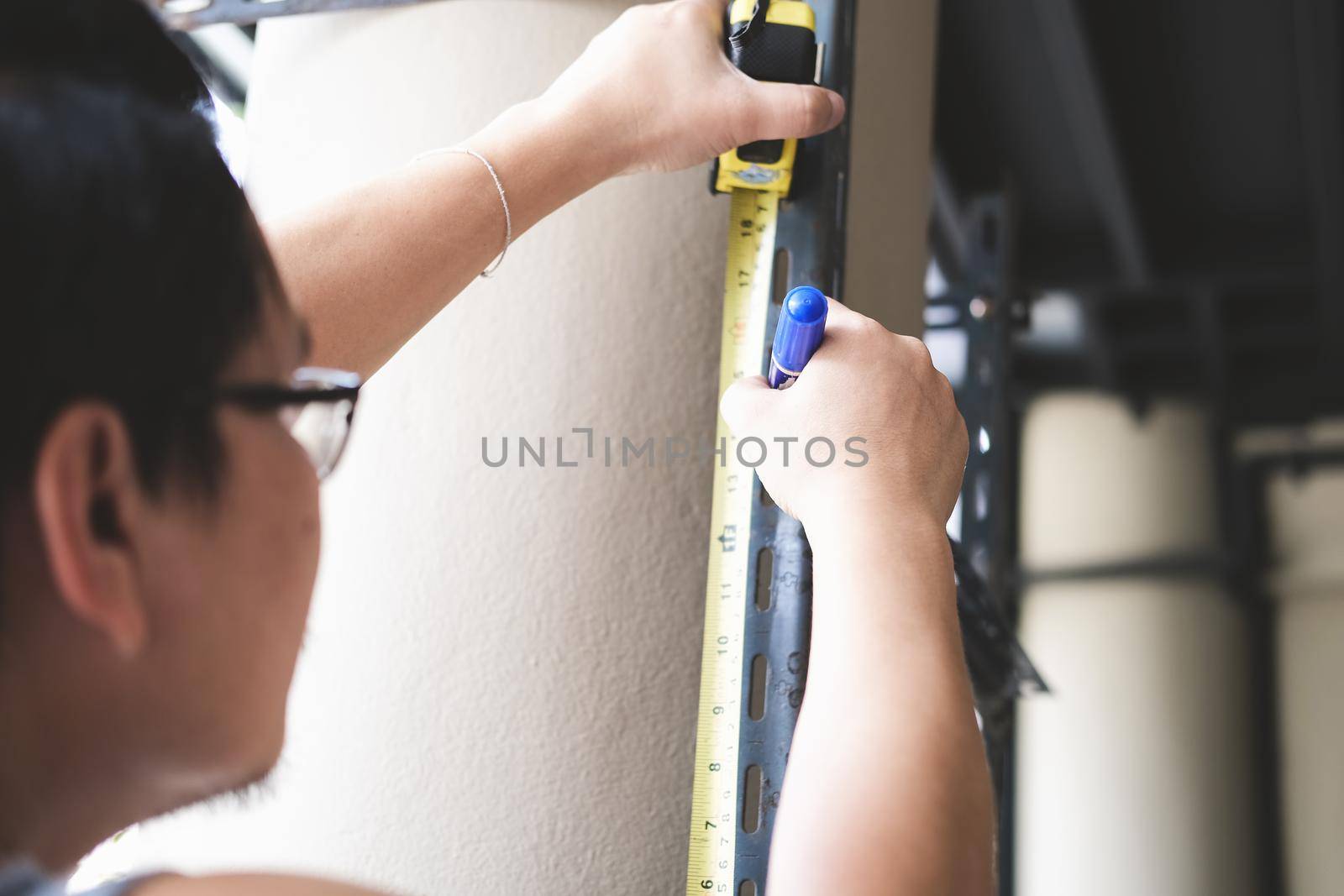 do-it-yourself concept Craftsmen use height measuring tapes to assemble old iron parts. Make a shelf for the weekend.