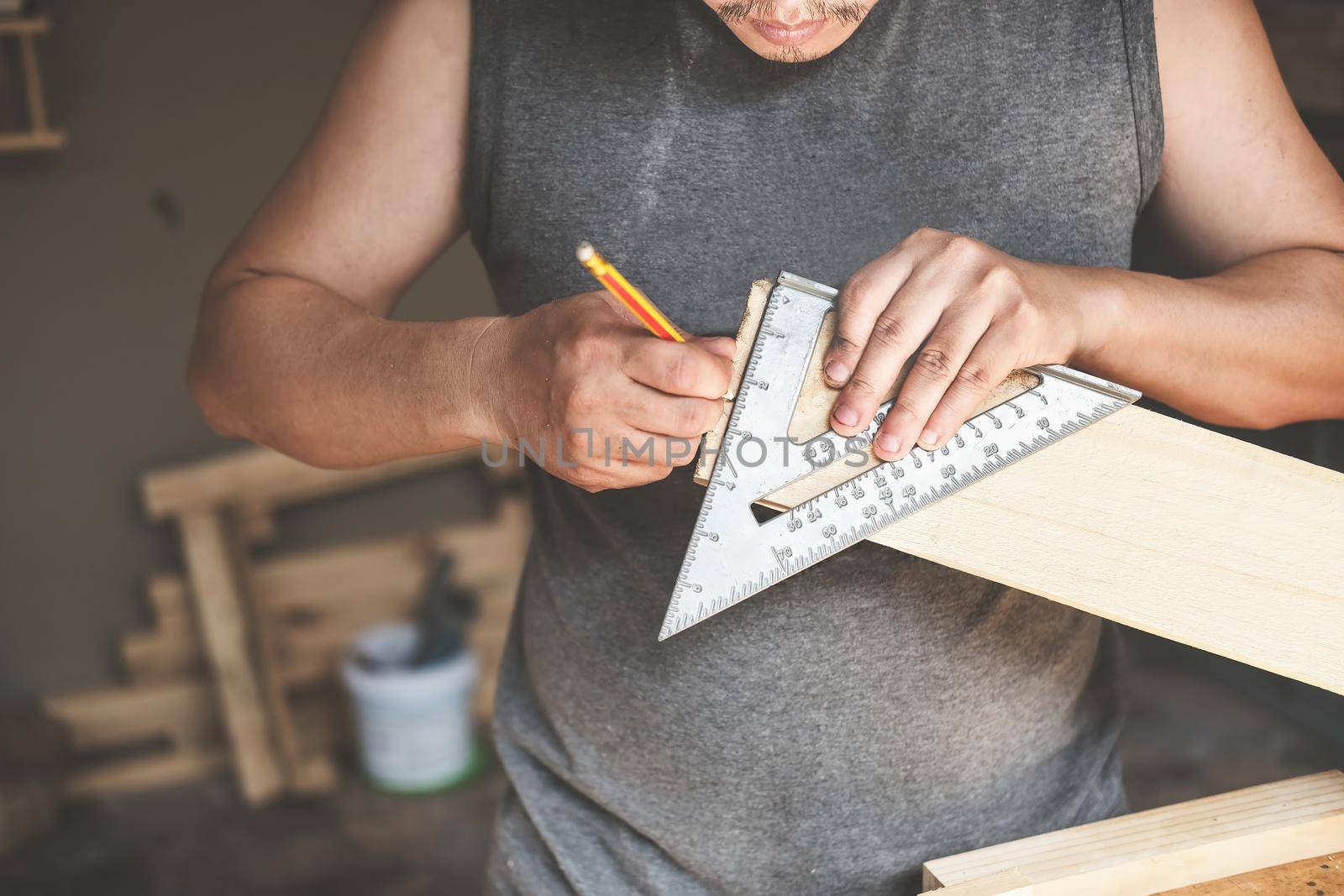 A carpenter measures the plates to assemble the parts. and build a wooden table for customers