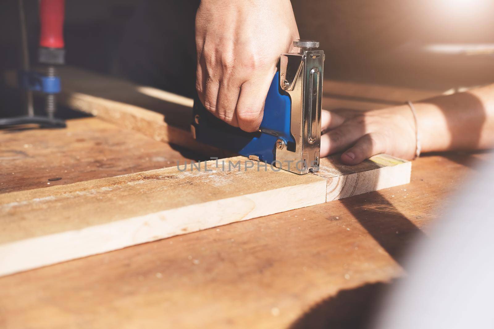 Entrepreneur Woodwork holding a Tacker to assemble the wood pieces as the customer ordered