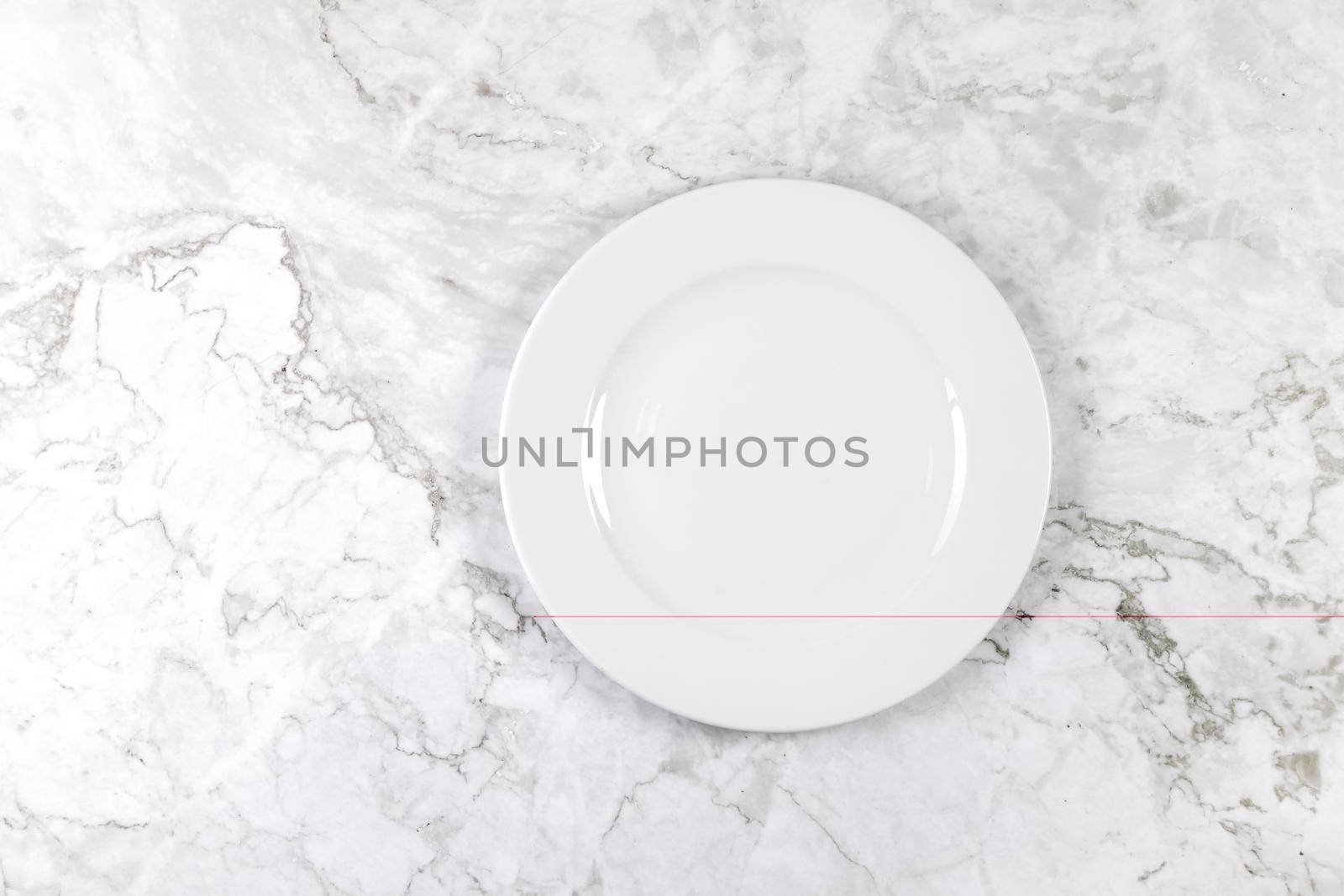 A dinner plate on a white and grey marble surface