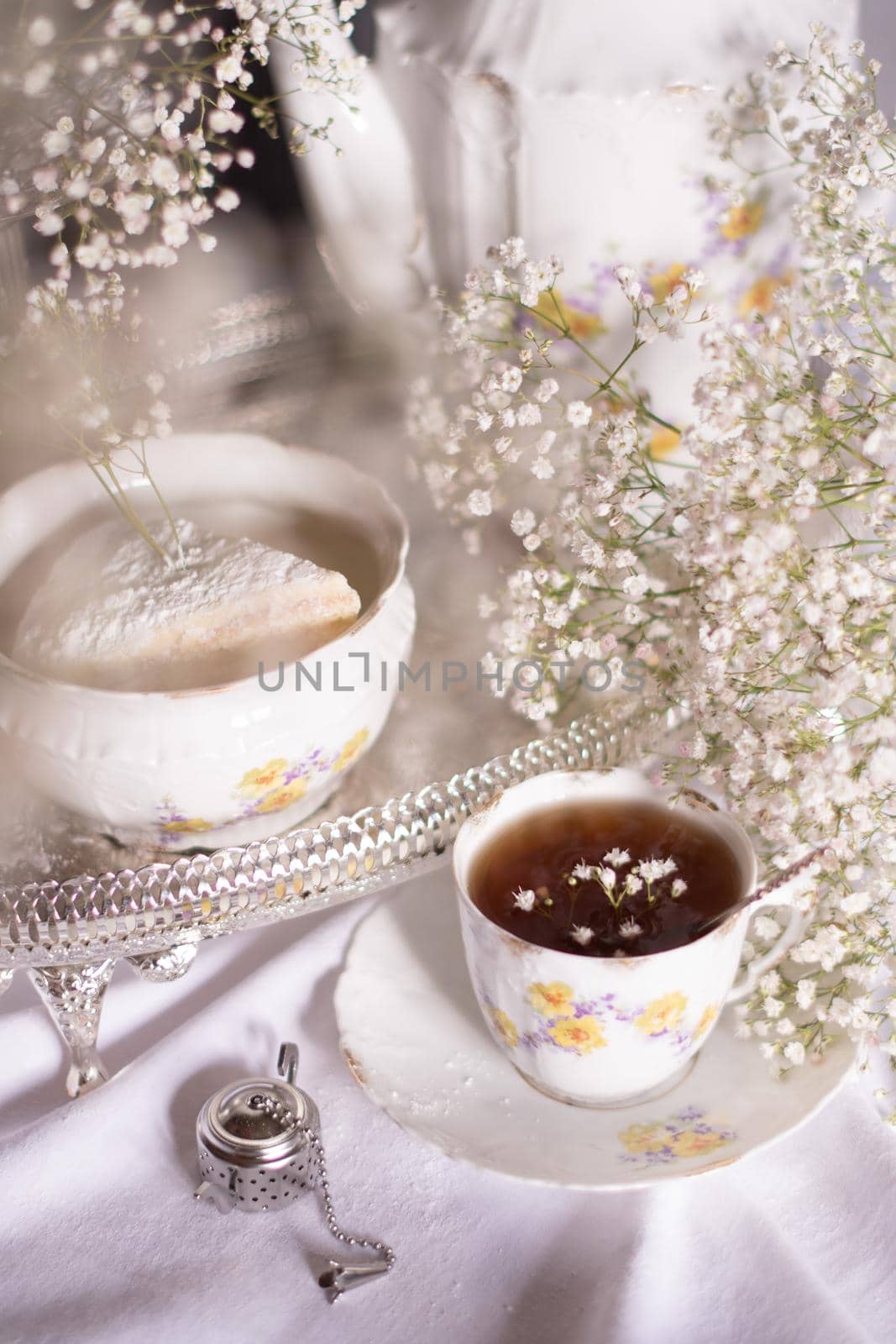 white still life with cheesecake gypsophila and cup of tea, light and airy, High quality photo,table setting for tea drinking in the English style