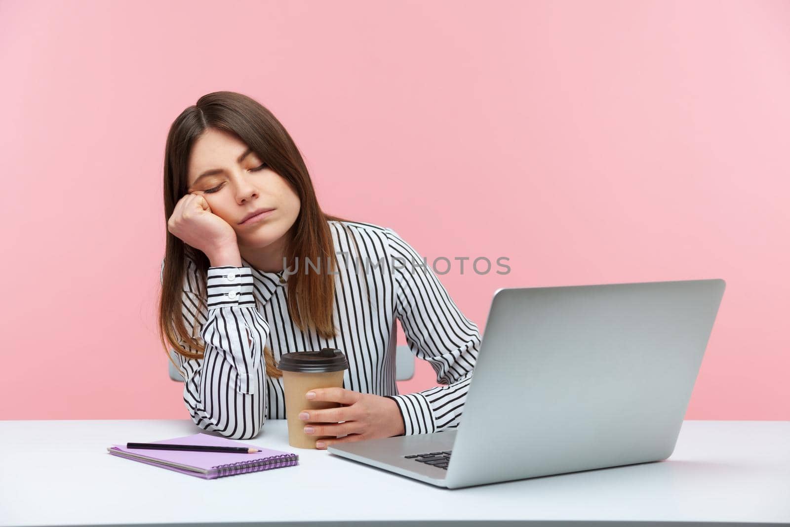 Emotional young woman sitting and working on office with pink background. by Khosro1