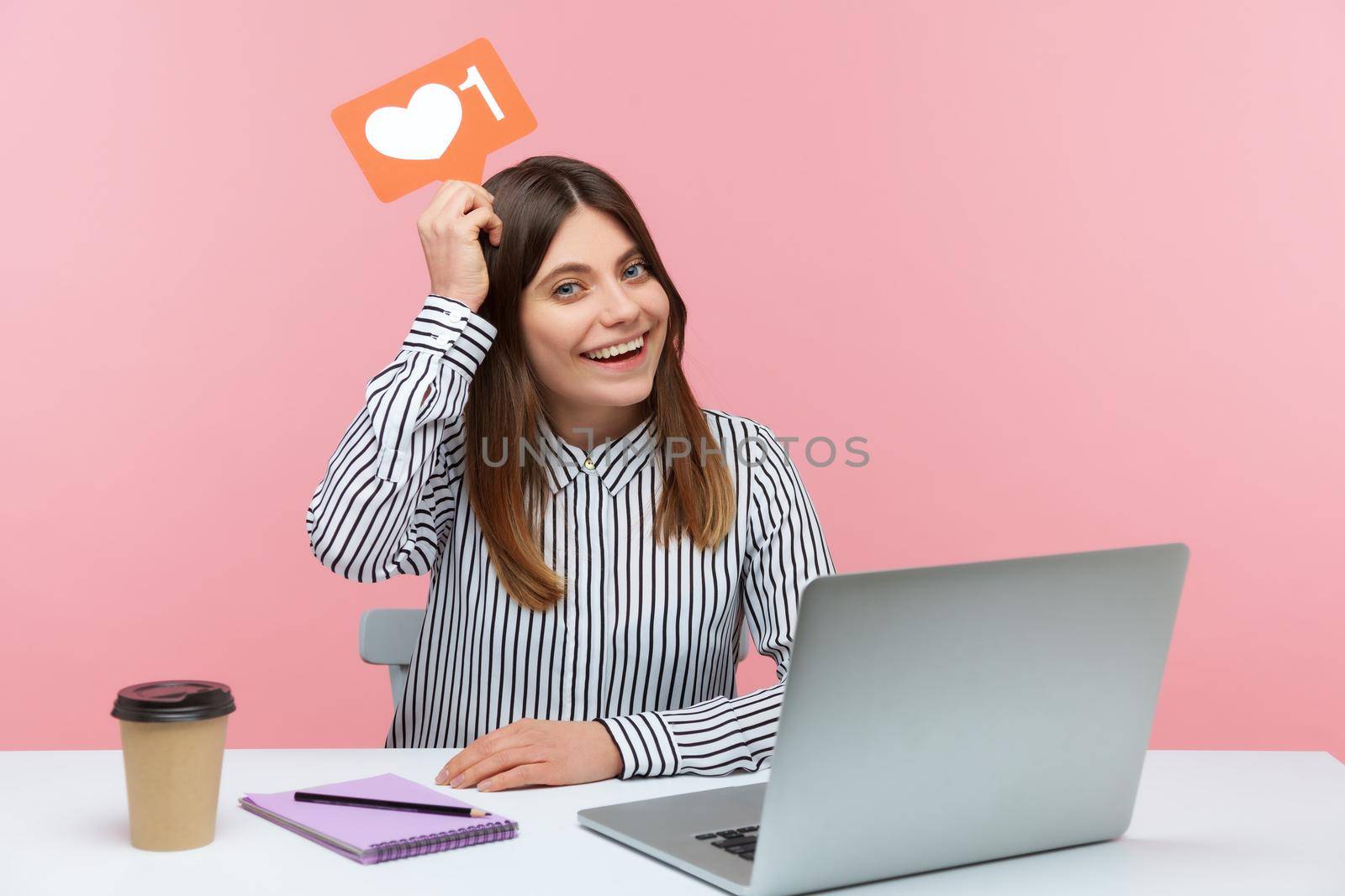 Emotional young woman sitting and working on office with pink background. by Khosro1