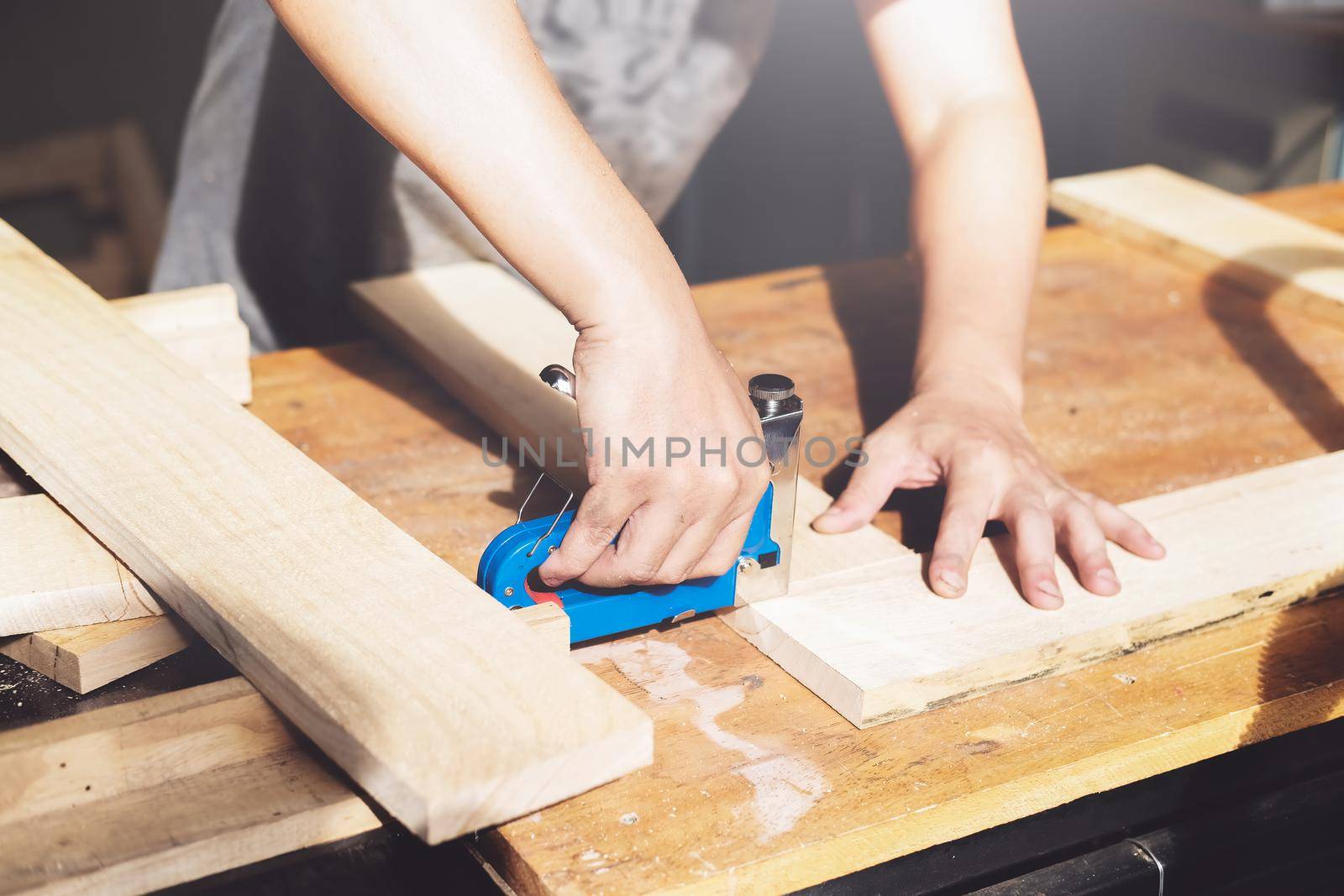 Entrepreneur Woodwork holding a Tacker to assemble the wood pieces as the customer ordered