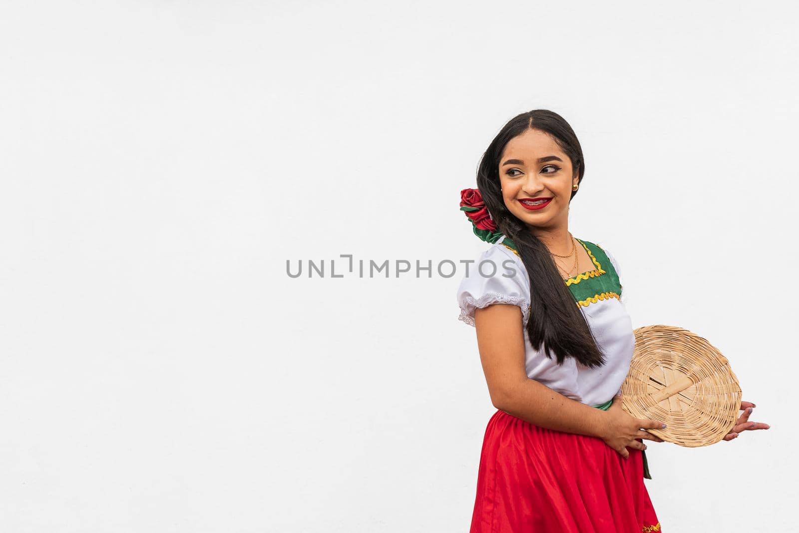 Portrait of young latin girl on white background holding a basket