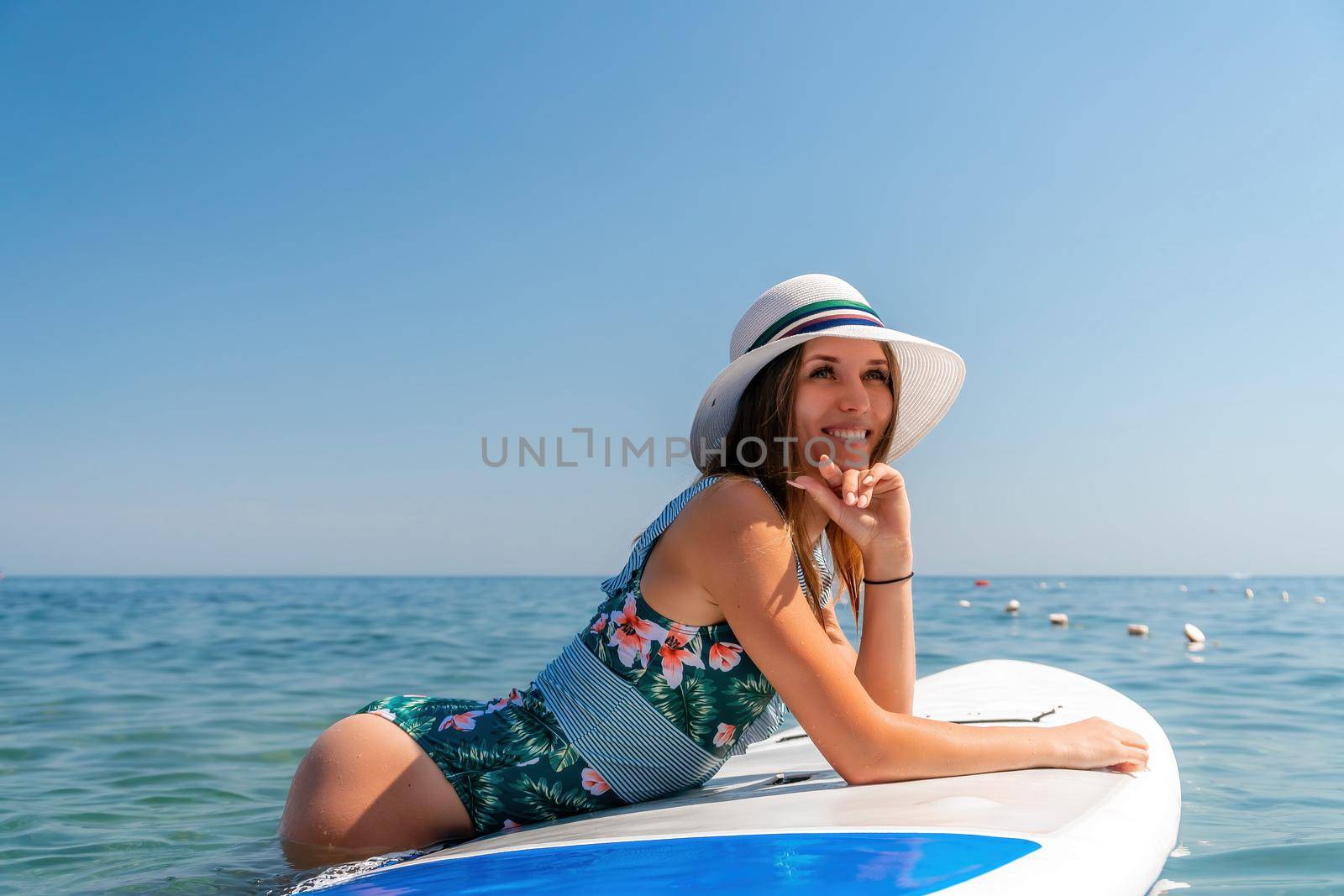 SUP Stand up paddle board. Young woman sailing on beautiful calm sea with crystal clear water. The concept of an summer holidays vacation travel, relax, active and healthy life in harmony with nature. by panophotograph