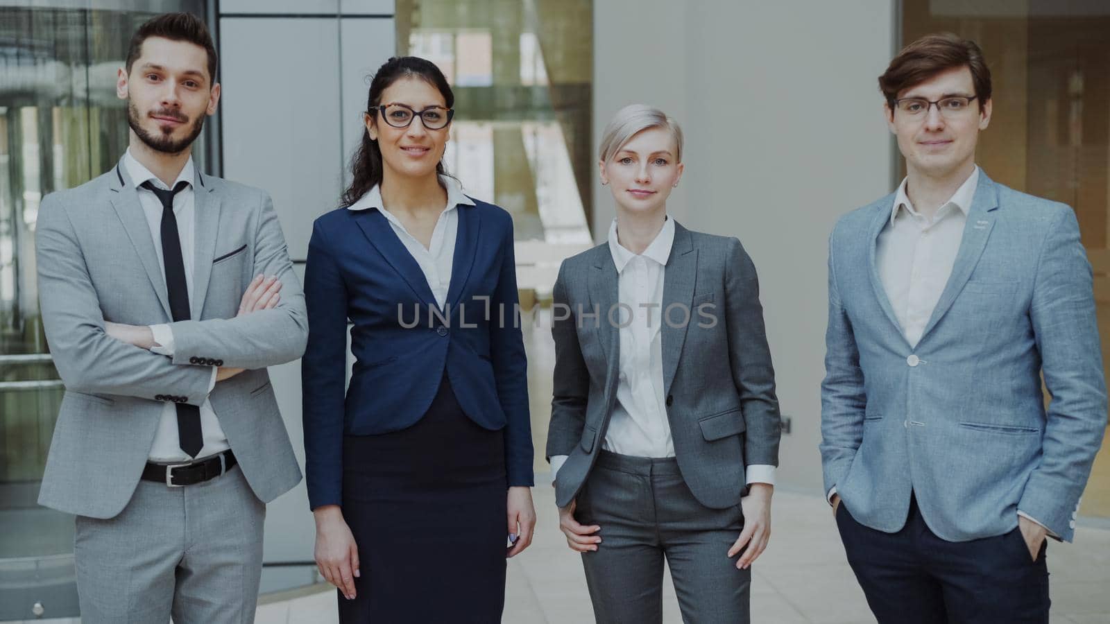 Portrait of group of business people smiling in modern office indoors. Team of businessmen and businesswomen standing together