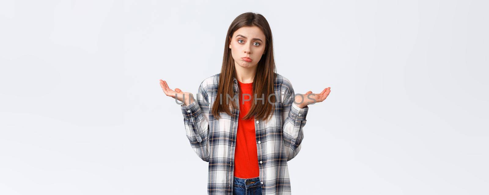 Lifestyle, different emotions, leisure activities concept. Reluctant and careless young woman shrugging with hands spread sideways, dont know, cant help, have no idea, stand white background by Benzoix