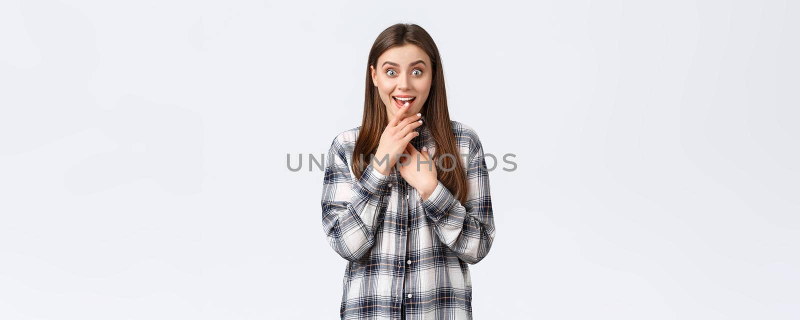 Lifestyle, different emotions, leisure activities concept. Excited and intrigued young girl want try new product, seeing advertisement on tv, biting finger in temptation and smiling by Benzoix