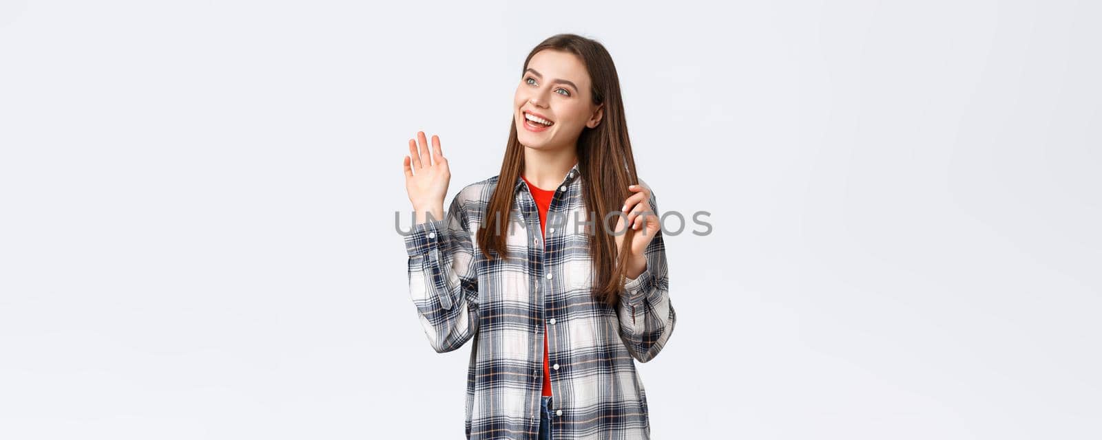 Lifestyle, different emotions, leisure activities concept. Cheerful, friendly attractive woman saying hi, meeting person at cafe, turn head and looking left, waving hello, greeting gesture.