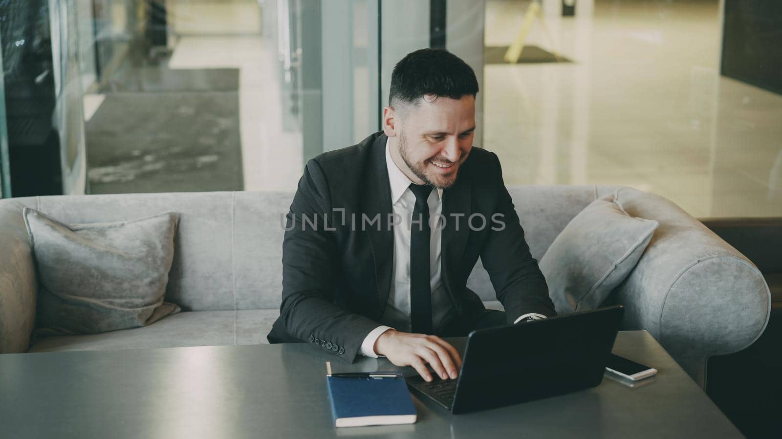 Successful businessman using laptop compute in classy cafe by silverkblack