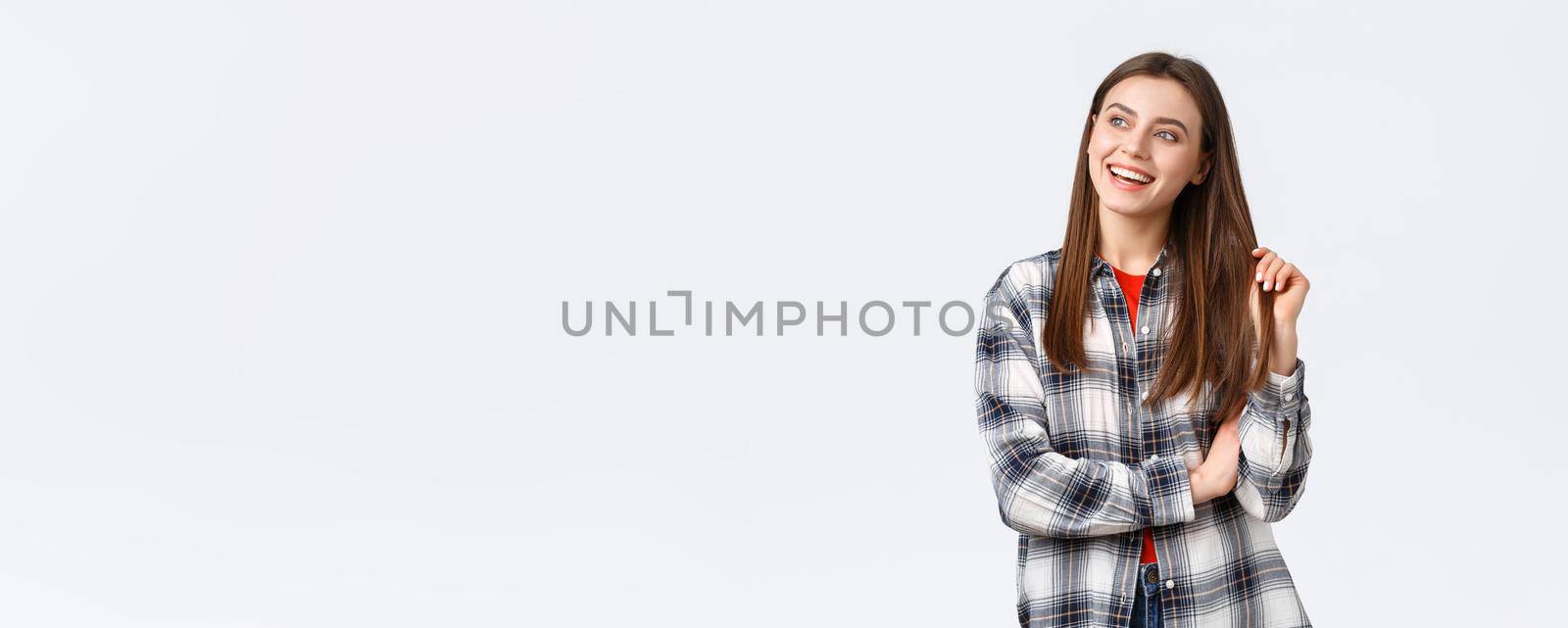 Lifestyle, different emotions, leisure activities concept. Dreamy and delighted, happy smiling woman, female student in checked casual shirt looking upper left corner with pleased expression.
