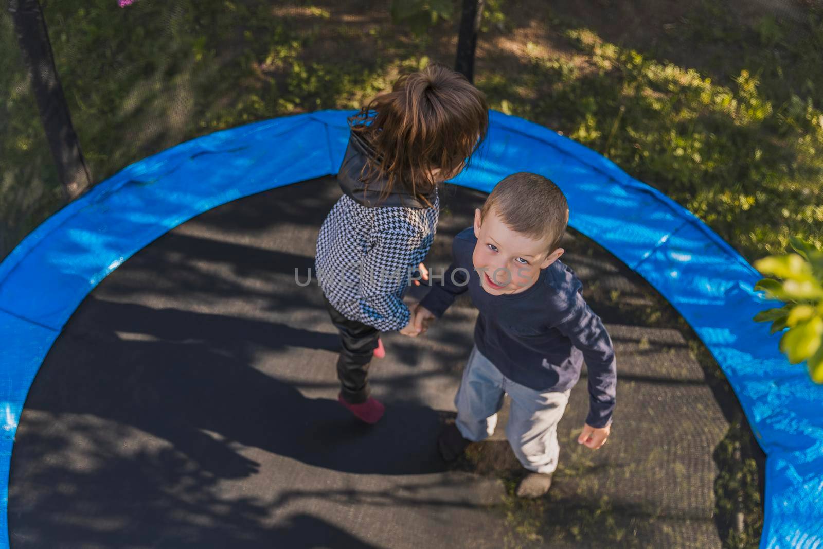top view of children jumping on a trampoline by zokov