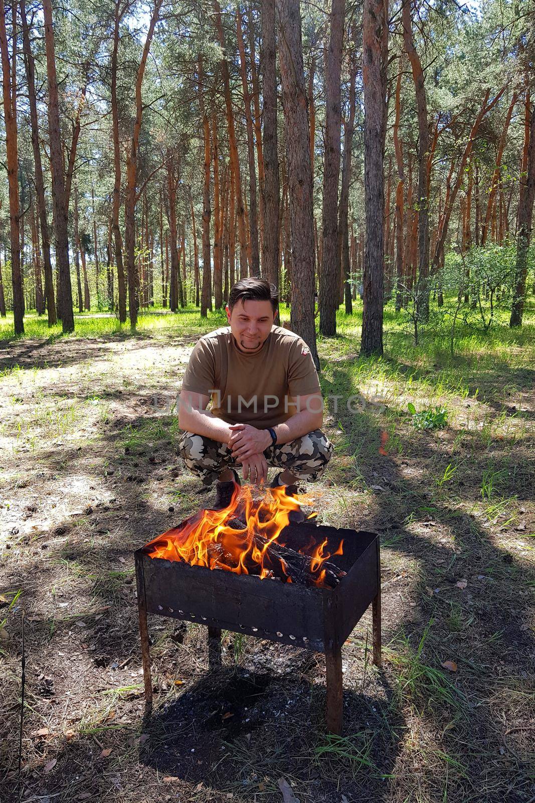 Man cooking Raw kebab, grilling on metal skewer. Meat roasting at barbecue. BBQ fresh beef chop slices. Traditional eastern dish. Grill on charcoal and flame, picnic, street food