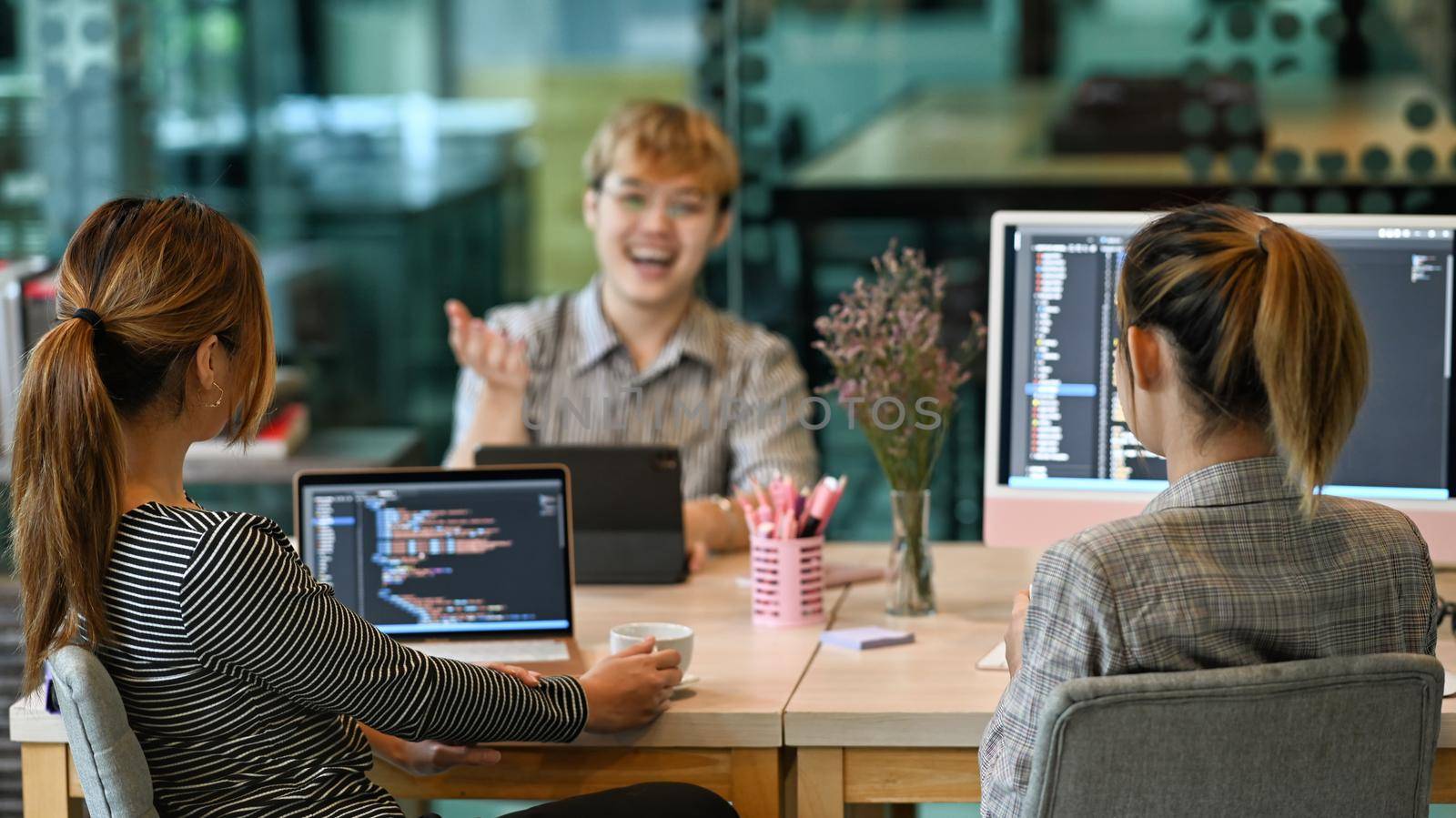 Group of software developers brainstorming and discussion for developing software applications at modern office by prathanchorruangsak