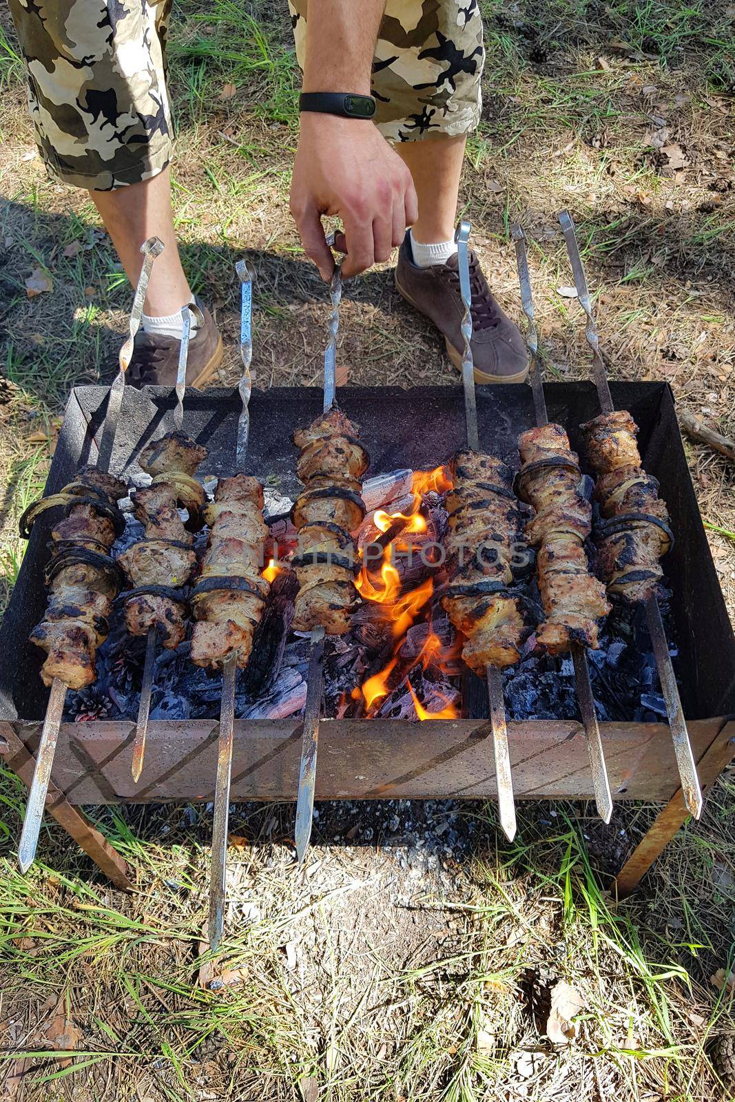 Raw kebab grilling on metal skewer. Meat roasting at barbecue. BBQ fresh beef chop slices. Traditional eastern dish. Grill on charcoal and flame, picnic, street food