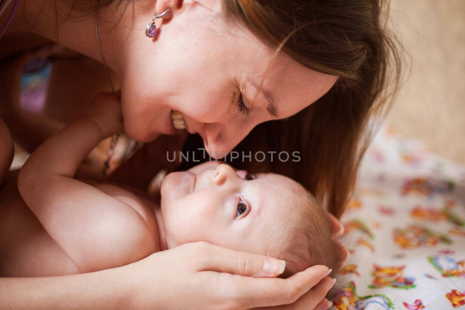 Close up portrait of beautiful young smiling mother kissing her newborn baby. Healthcare and medical love lifestyle mothers day concept