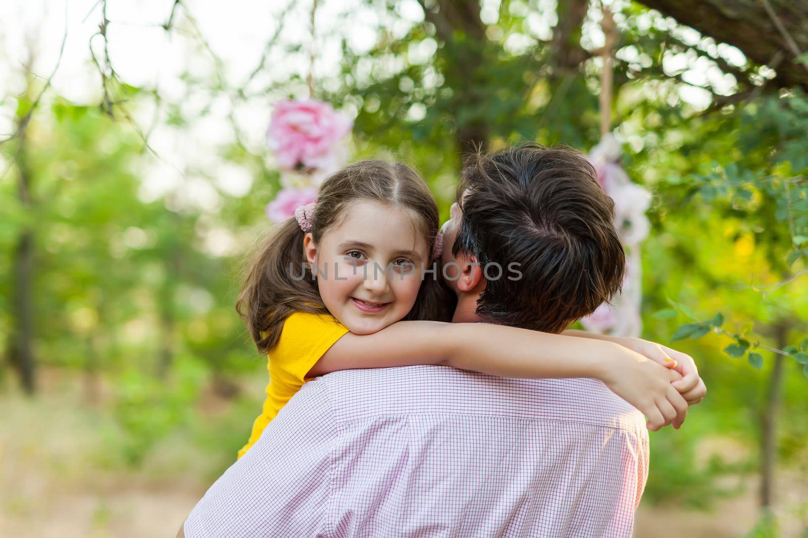 Smiling little girl hugging her father outside