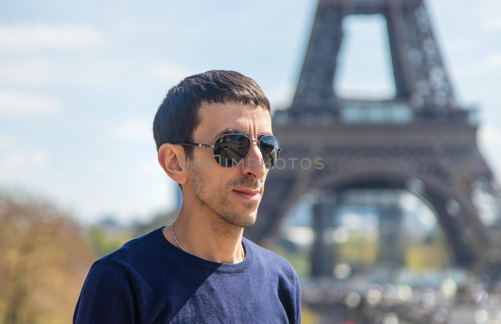 A man near the eiffel tower. Selective focus. People.