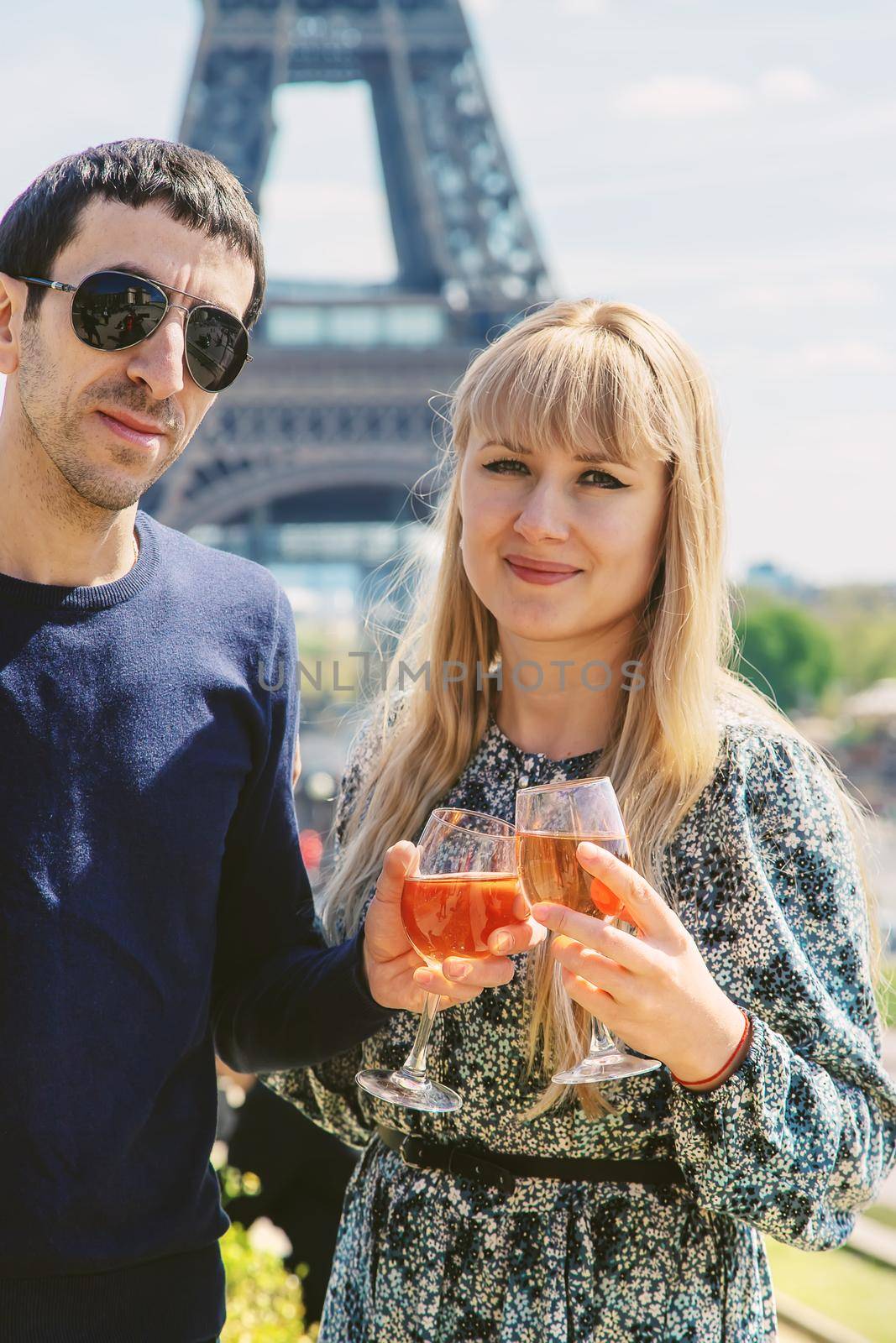 Man and woman with wine near the eiffel tower. Selective focus. by yanadjana
