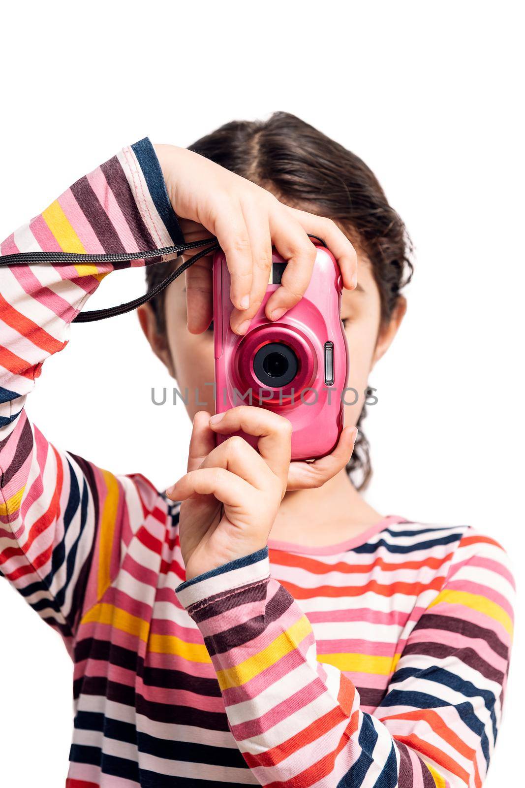 vertical photo of a little girl isolated on a white background taking pictures with her pink camera, concept of children and their hobbies