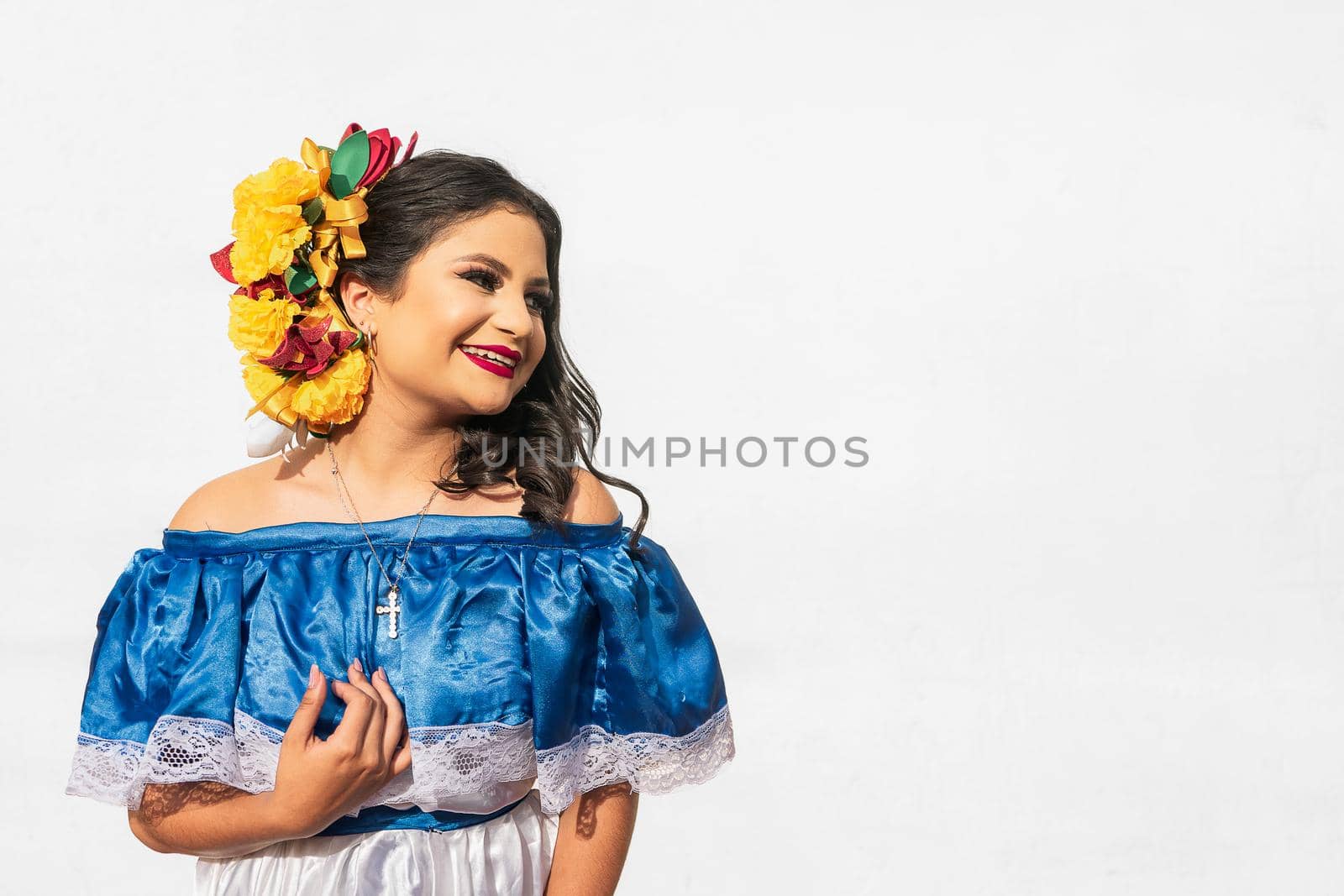Portrait of young beutiful latin girl on white background fixing hair and smiling