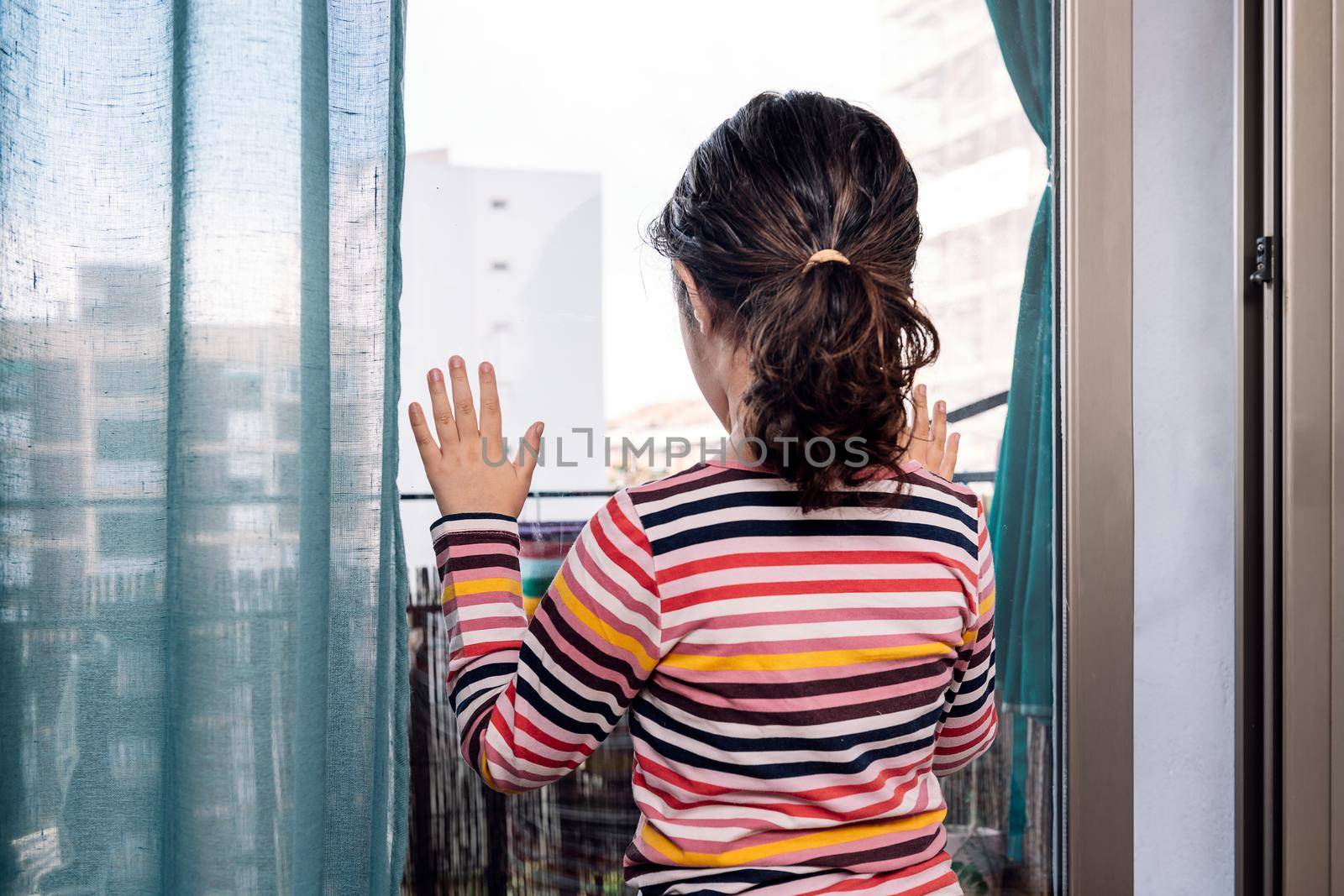 little girl looking through the window at home by raulmelldo