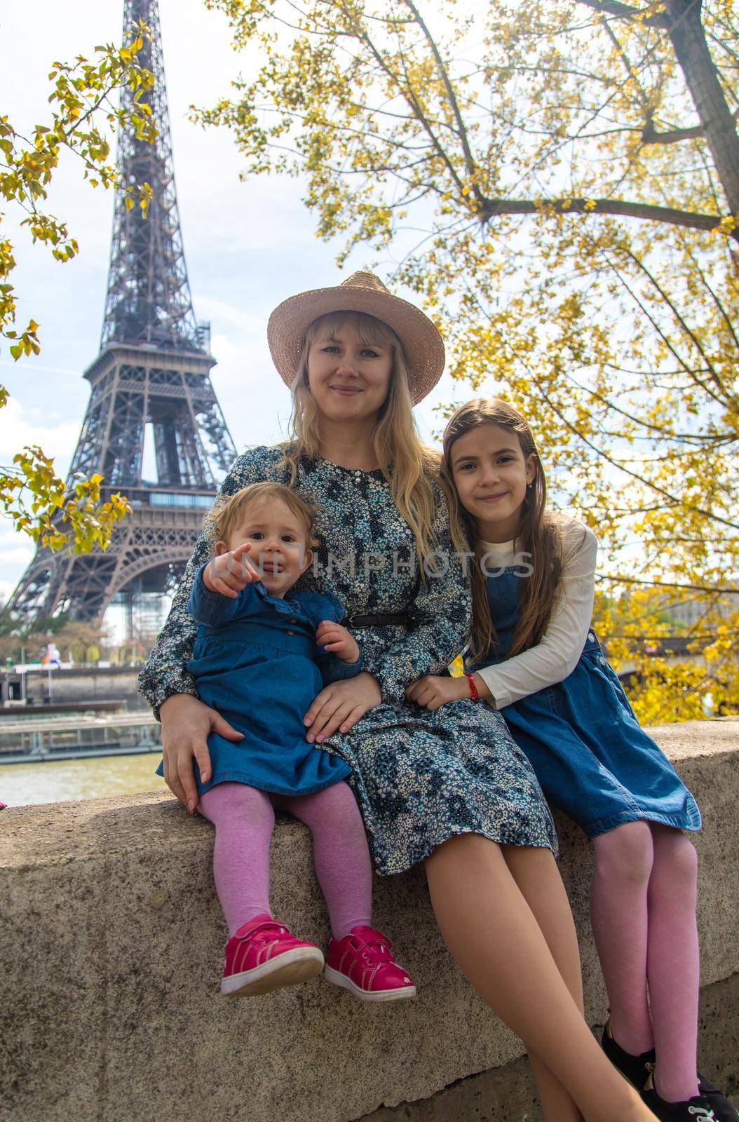 Woman with children near the eiffel tower. Selective focus. Kids.