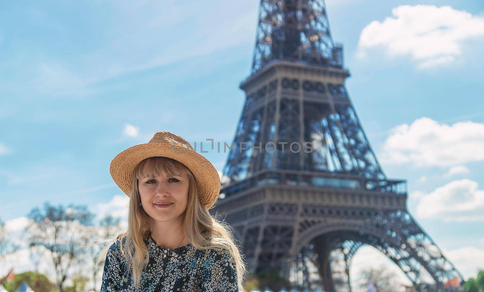 A woman in a hat looks at the Eiffel Tower. Selective focus. by yanadjana