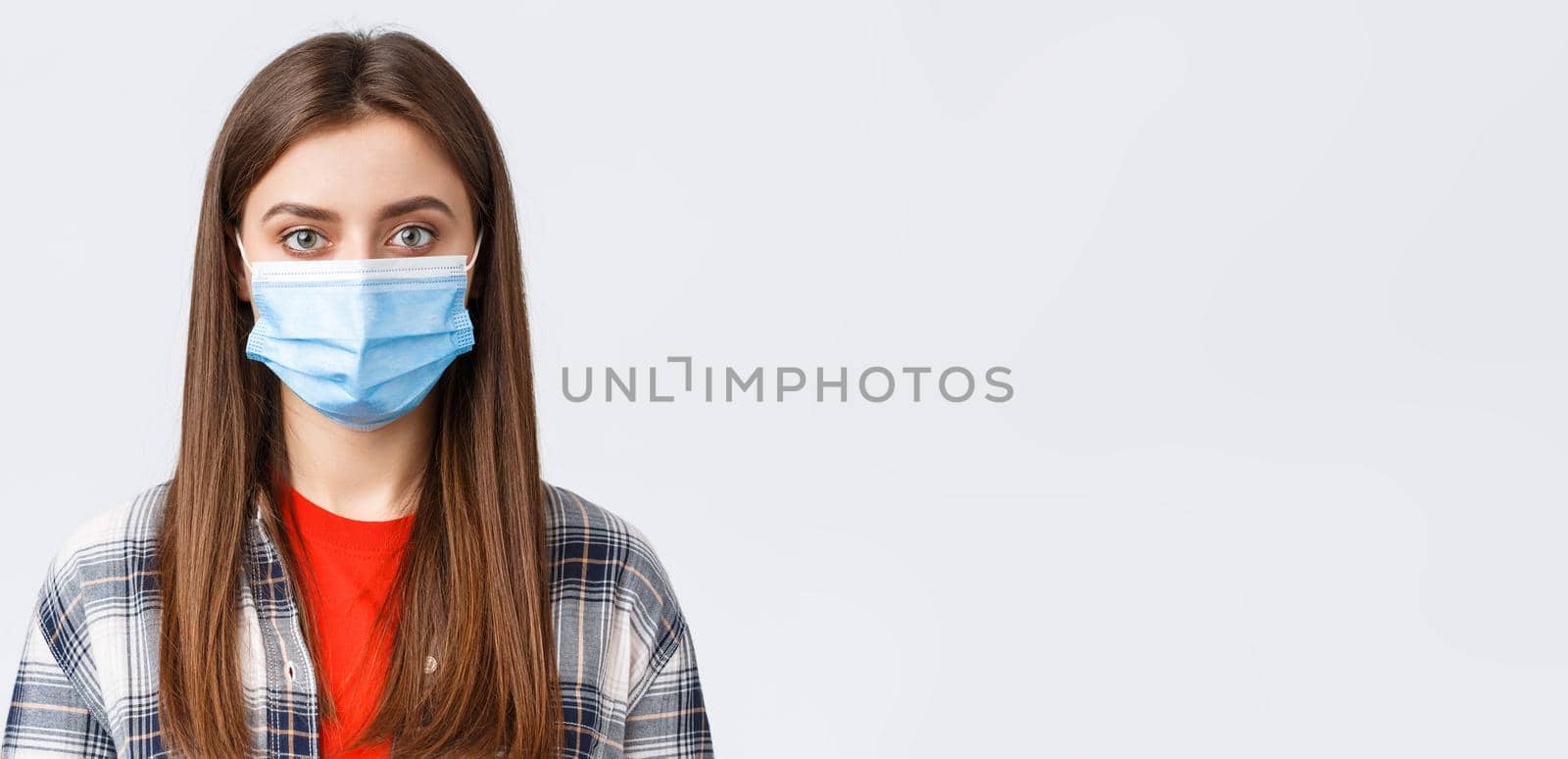 Coronavirus outbreak, leisure on quarantine, social distancing and emotions concept. Close-up of young female student, girl in medical mask looking at camera, normal expression by Benzoix