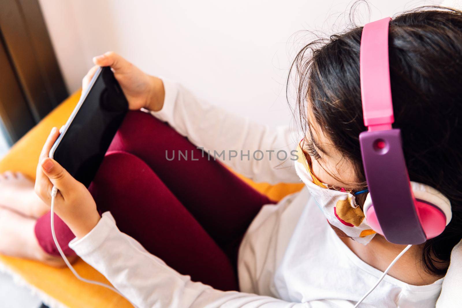 child with headset and mask playing with the phone by raulmelldo