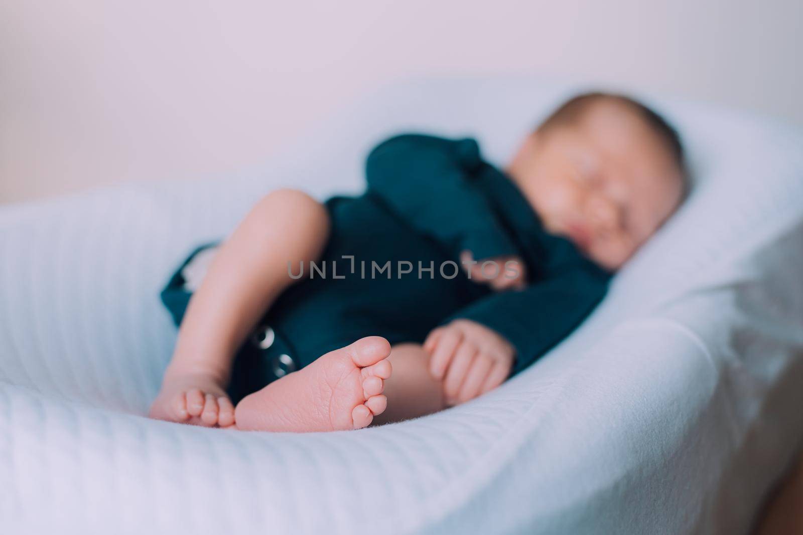 The baby is lying in a cocoon of copy space . The baby is 0-3 months old. A contented infant. An article about choosing a cocoon for newborns. An article about the benefits of cocoon. An article about colic .