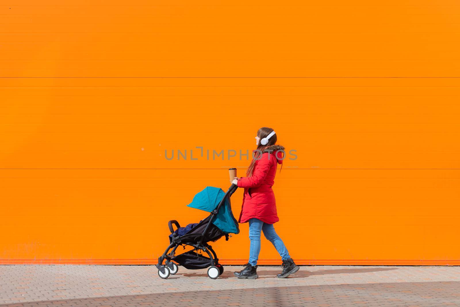 Mom on a walk with a stroller lifestyle. An article about choosing a stroller. An article about walking with children. The use of fresh air for kids. Modern moms. City walks with a stroller .