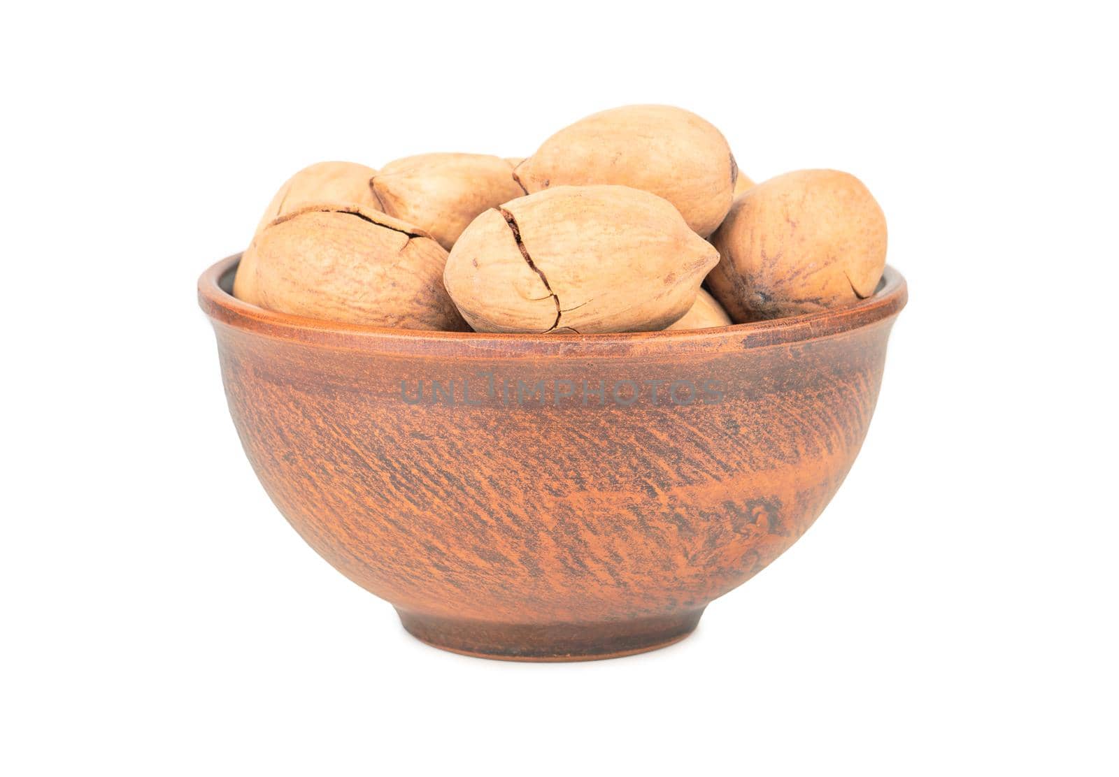 Pecan nuts in shell and bowl on white background