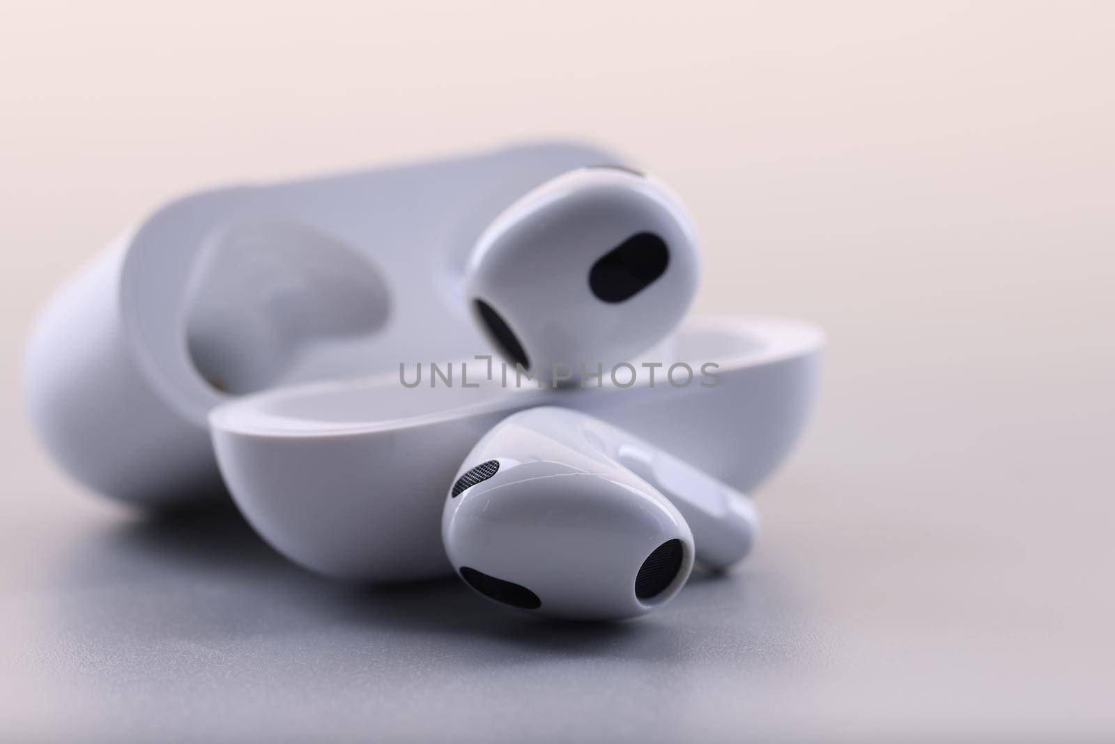 White electronic bluetooth headphones and technical cases on white background. Fashion stylish headphones concept