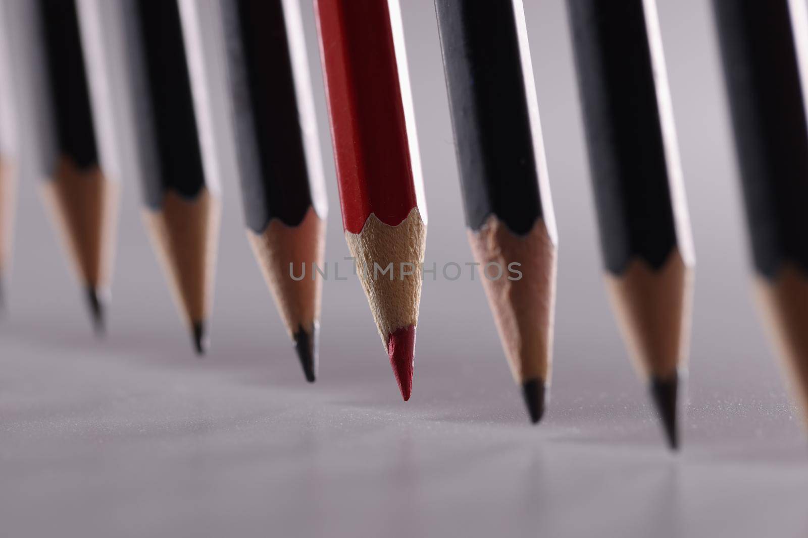 Black pencils in the center with red. Leadership uniqueness and business success concept