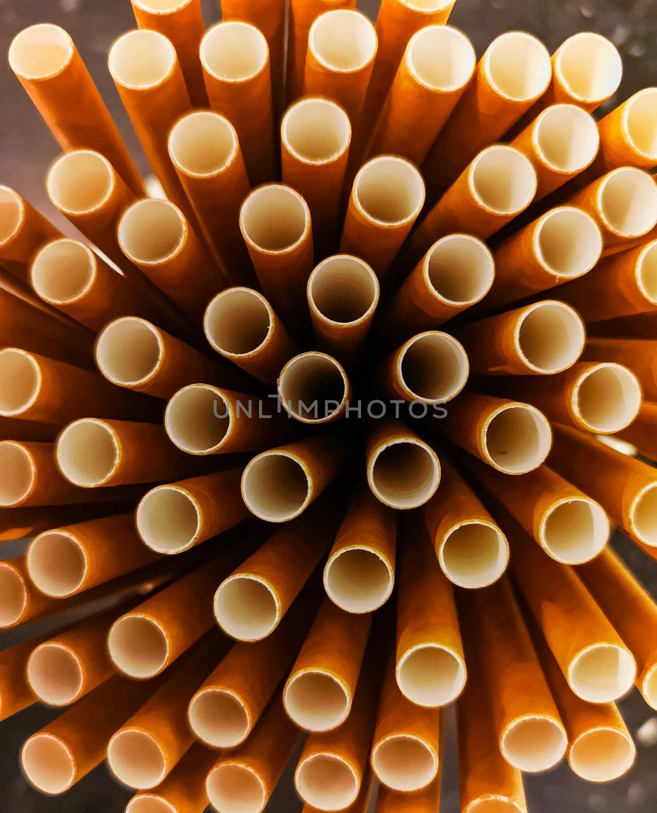 Stack of paper straws standing in high glass 