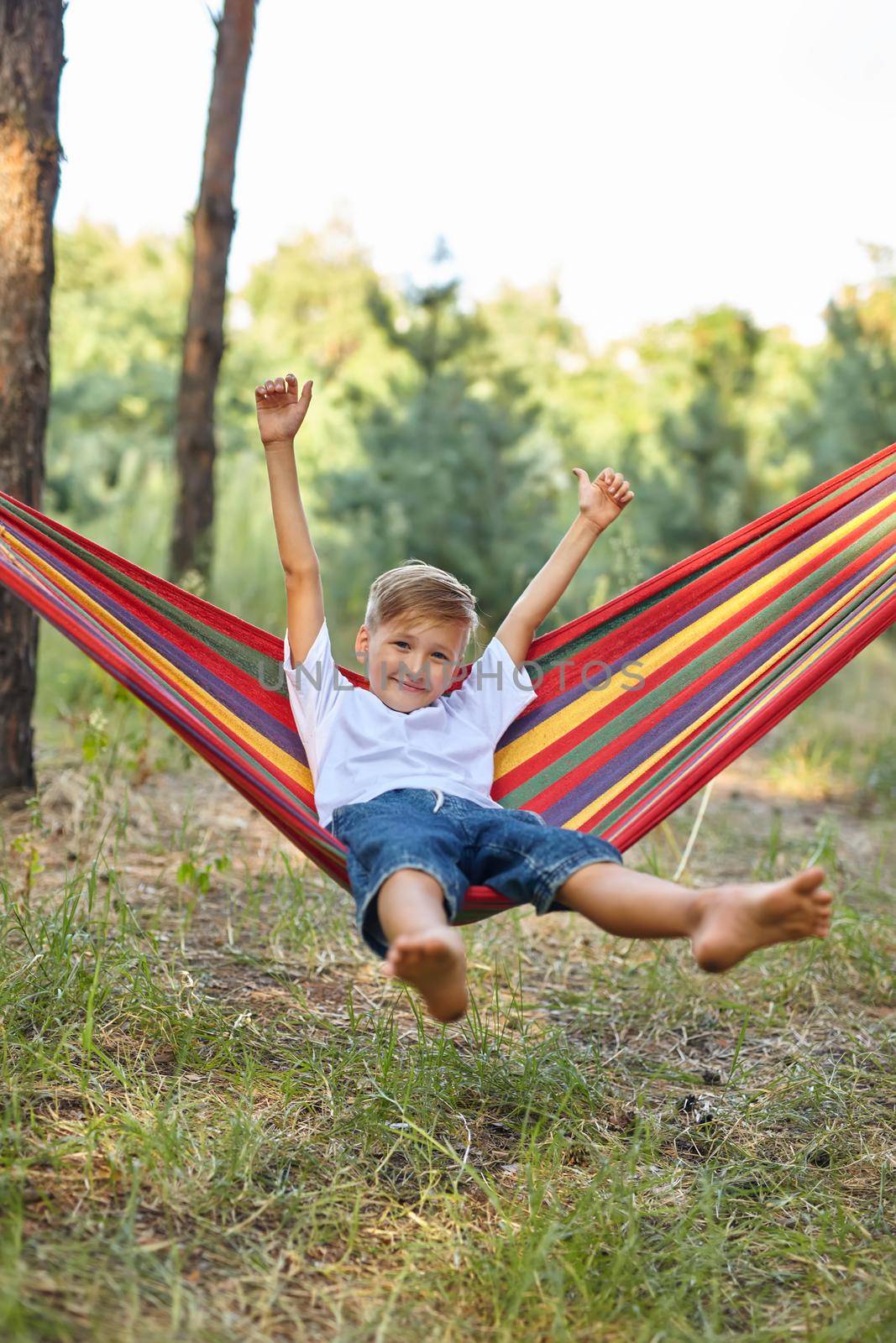 Cute boy is sitting in a hammock. by InnaVlasova