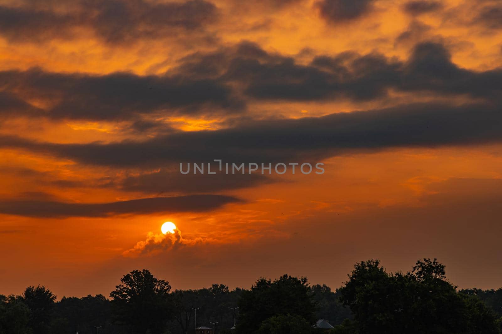 Beautiful cloudy sunrise over big yellow field and trees of forest by Wierzchu