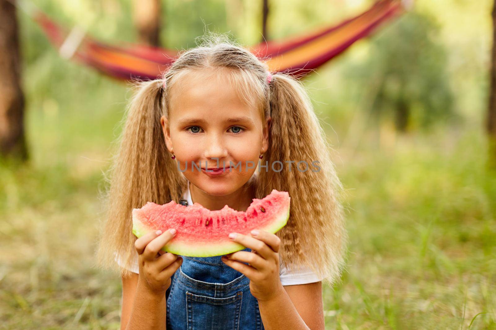 Funny girl eating watermelon in the park. by InnaVlasova